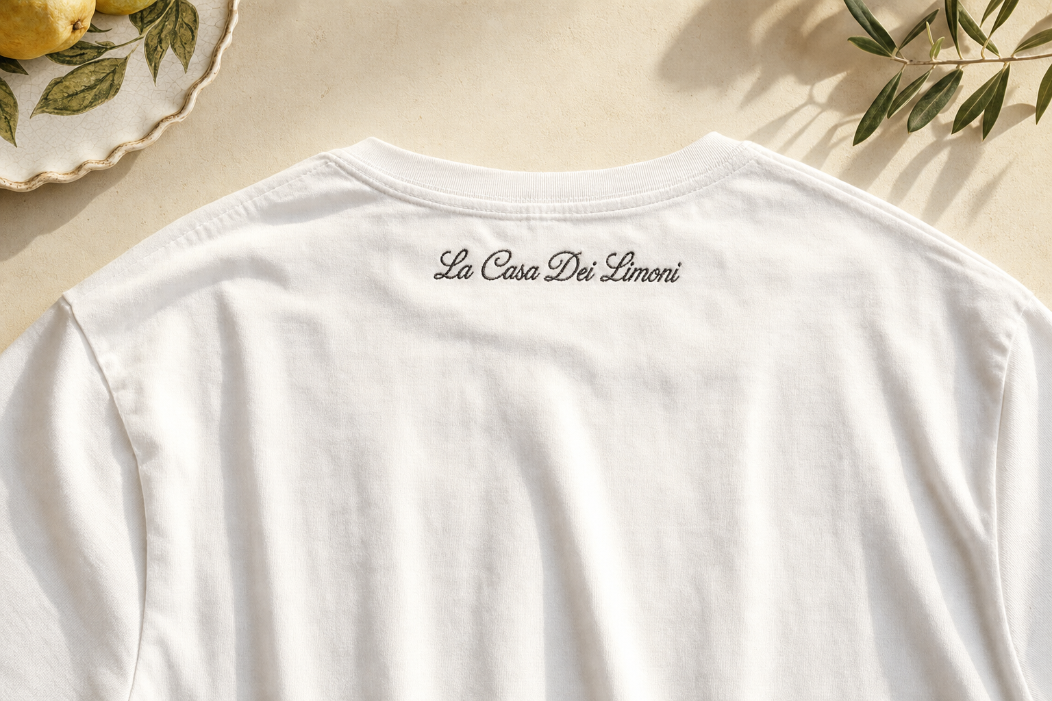The Founding Tee — back view, with 'La Casa Dei Limoni' embroidered in script below the collar